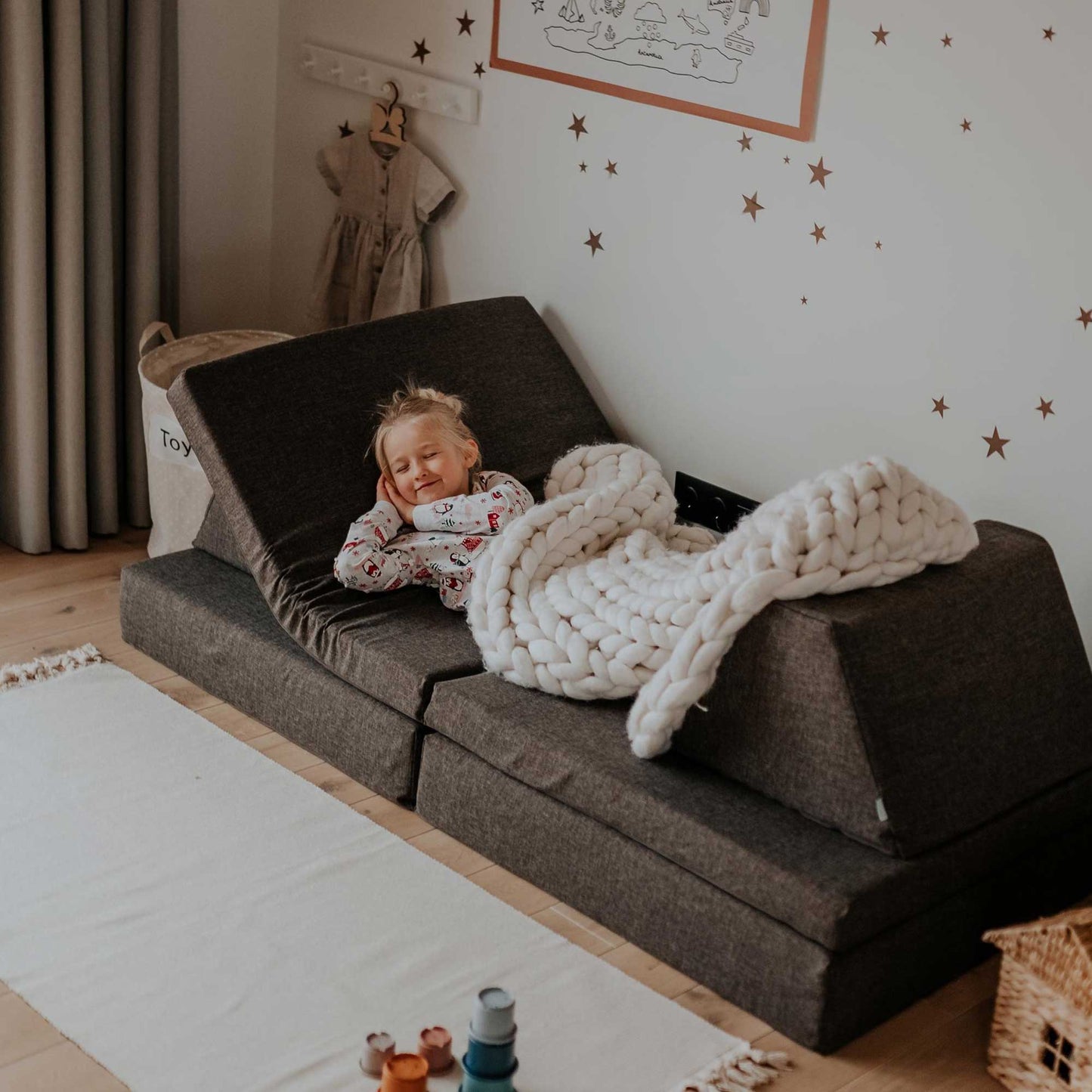 A toddler girl sleeping on a dark brown Monboxy play couch set