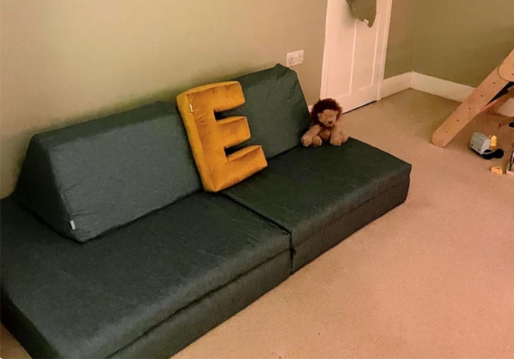 A deep green Monboxy Montessori activity couch set in a customer's house
