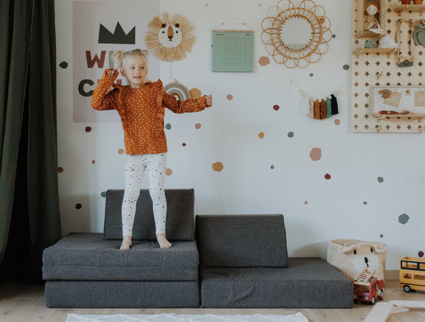 A girl jumping on a Monboxy play couch set and laughing