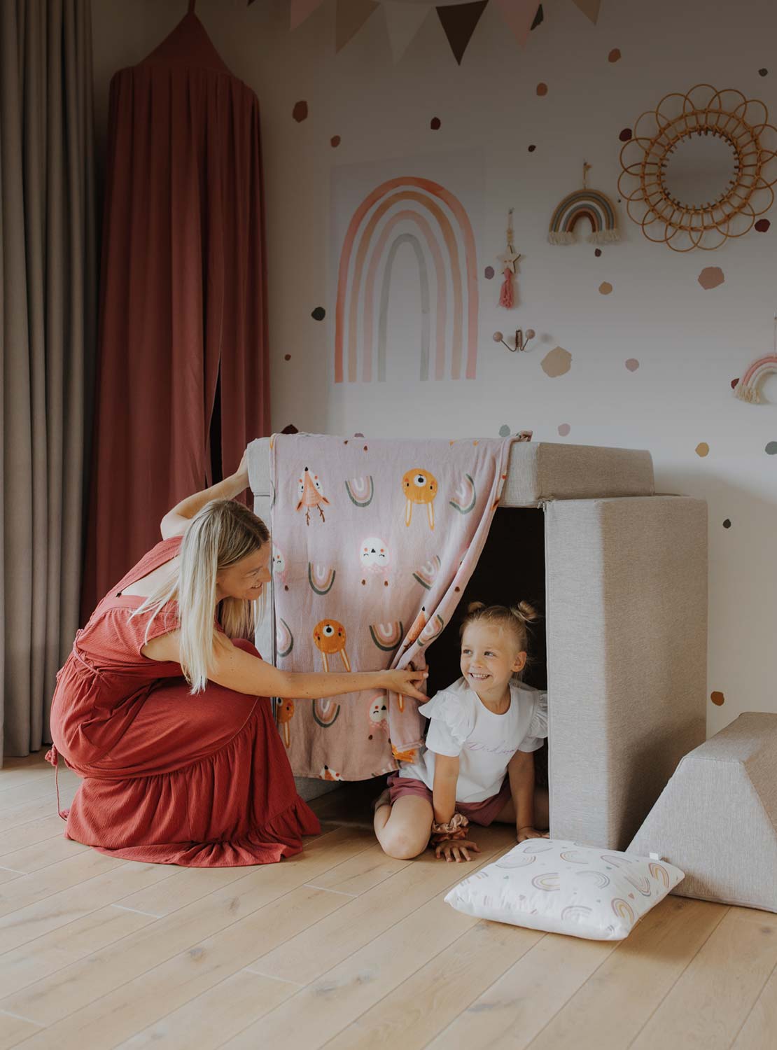 Mom and daughter playing hide and seek in their activity couch