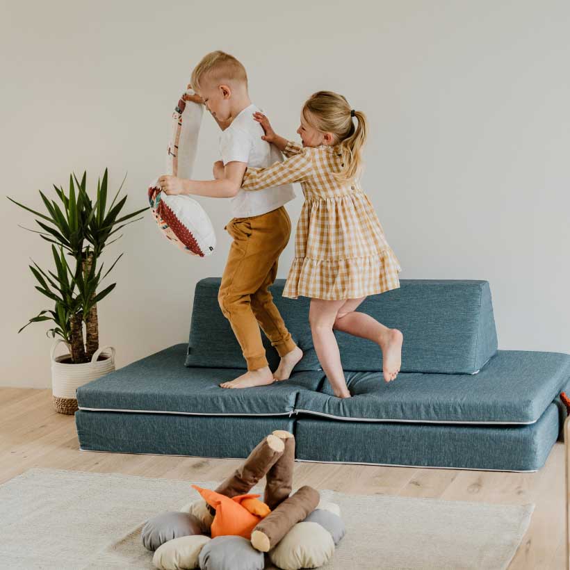 Children actively playing on their turquoise Monboxy play sofa set