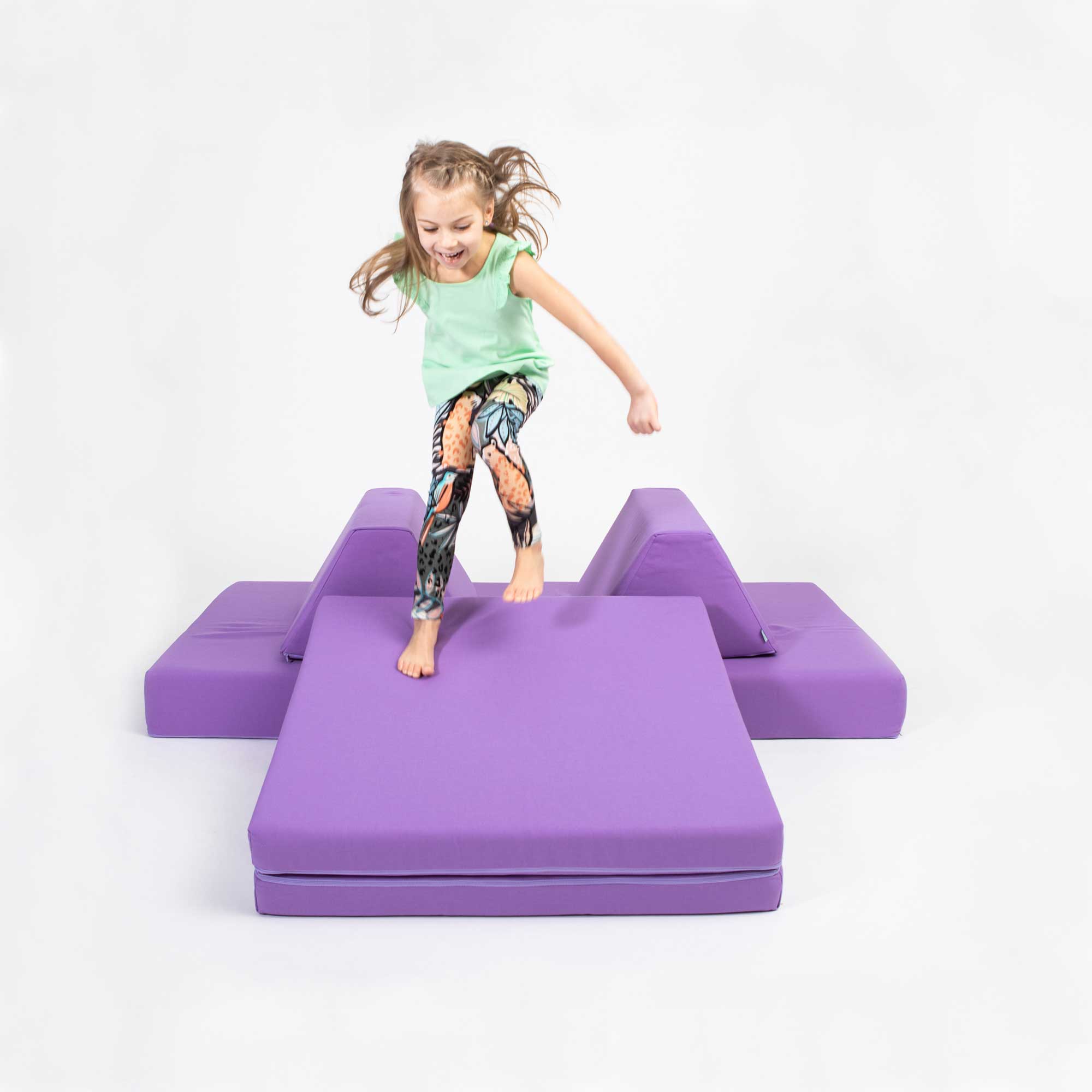 A girl jumping on her Purple Monboxy montessori sofa set