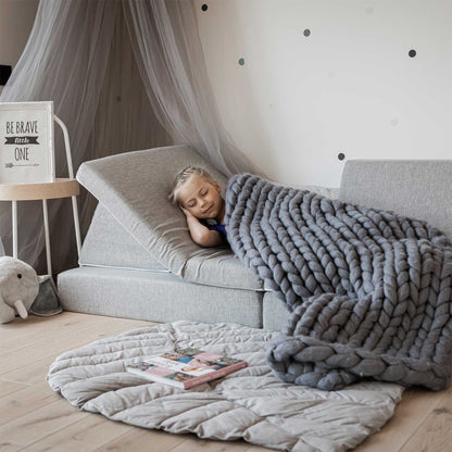 A girl sleeping on her grey Monboxy foam sofa set, covered with a blanked