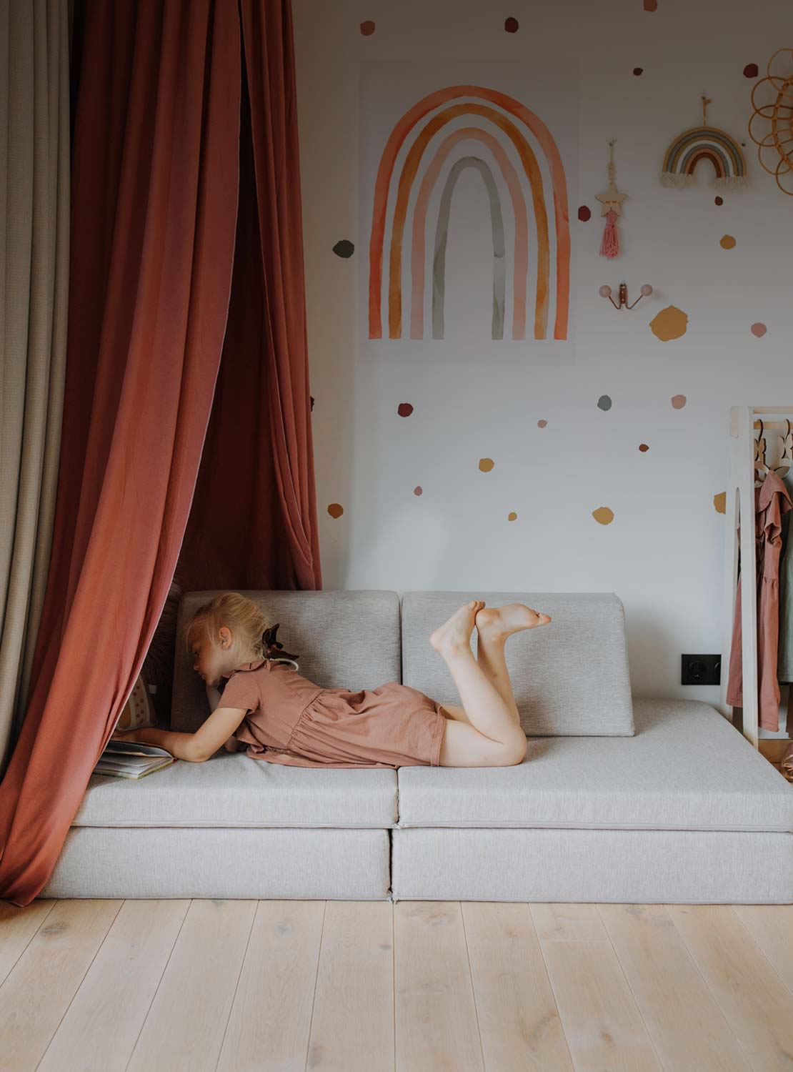 A girl laying down on a sofa and reading in her room