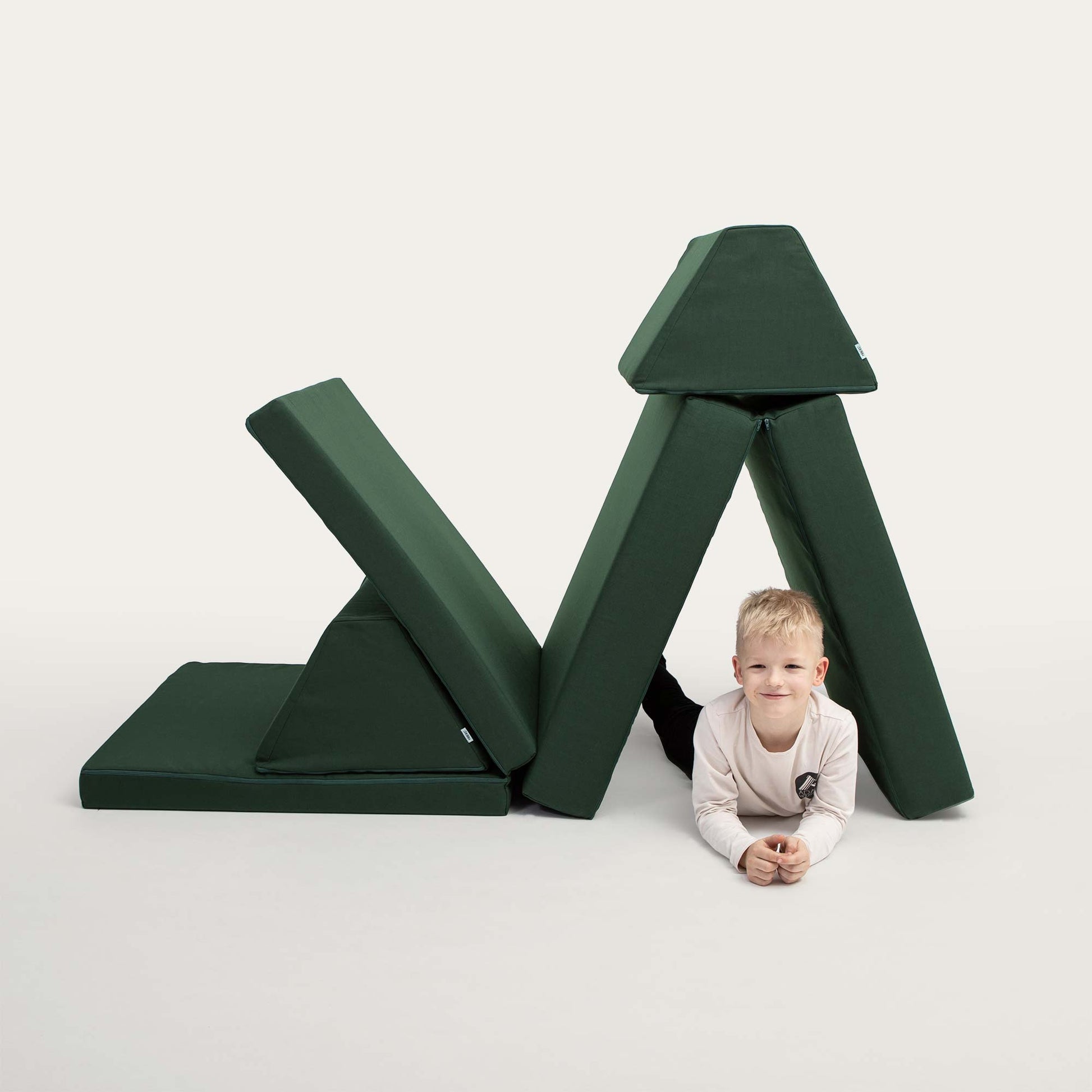 A toddler boy playing with his Deep Green Monboxy play sofa set