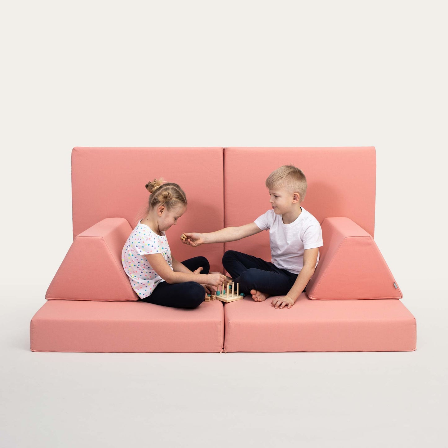 A boy and a girl playing on their Salmon pink Monboxy activity couch set for toddlers