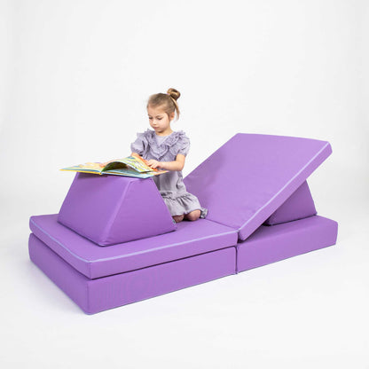 A girl reading a book and relaxing on a pruple Monboxy activity couch set for kids