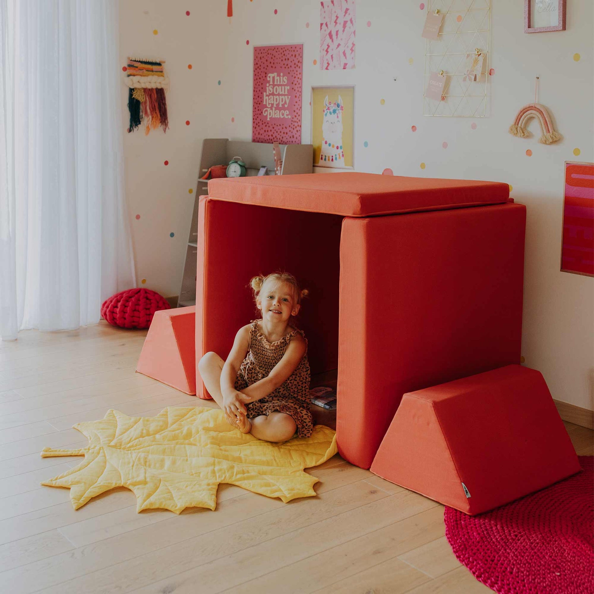 Bright colored play couch set fort with girl inside it